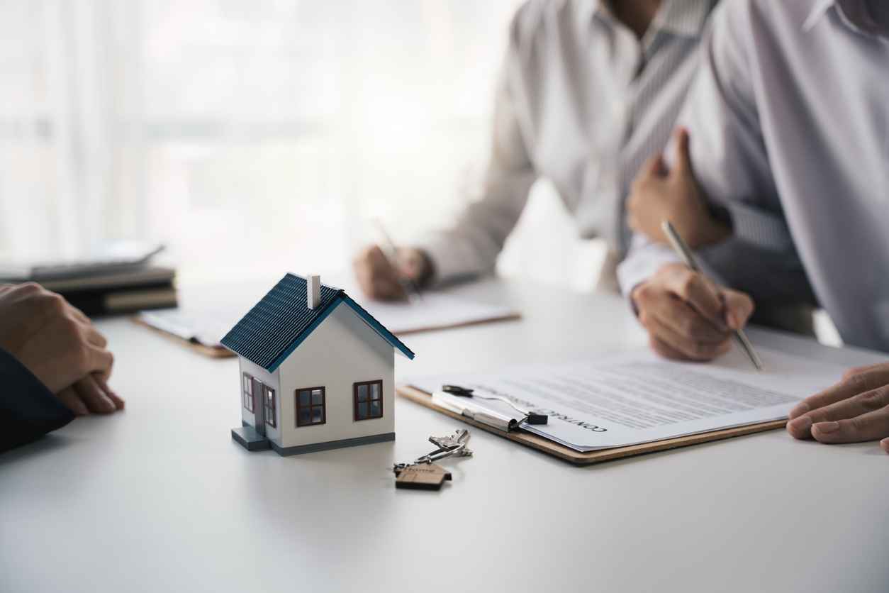 Customer writing signing signature on paper contract with real estate agent and receive sample home, Agreement to sign the purchase contract concept.